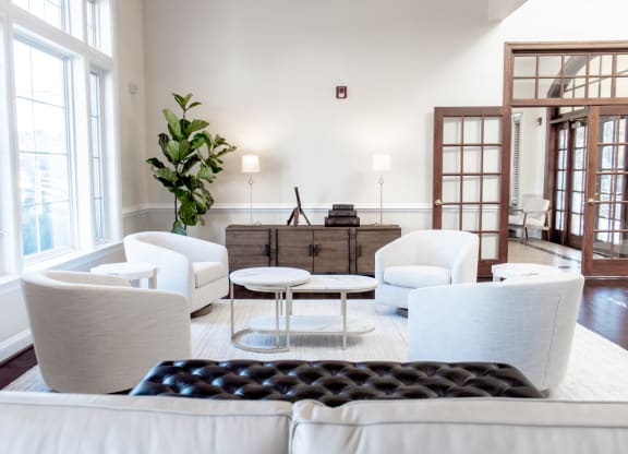 a living room with white furniture and large windows at Broadlands Apartments, 20148